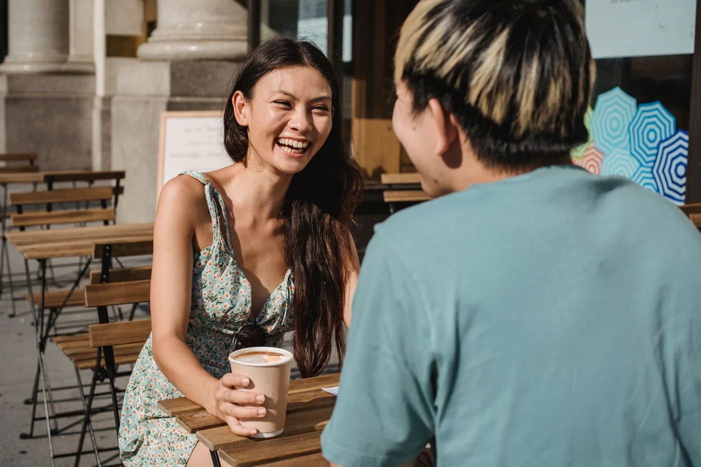 Two people enjoying a conversation over coffee outdoors